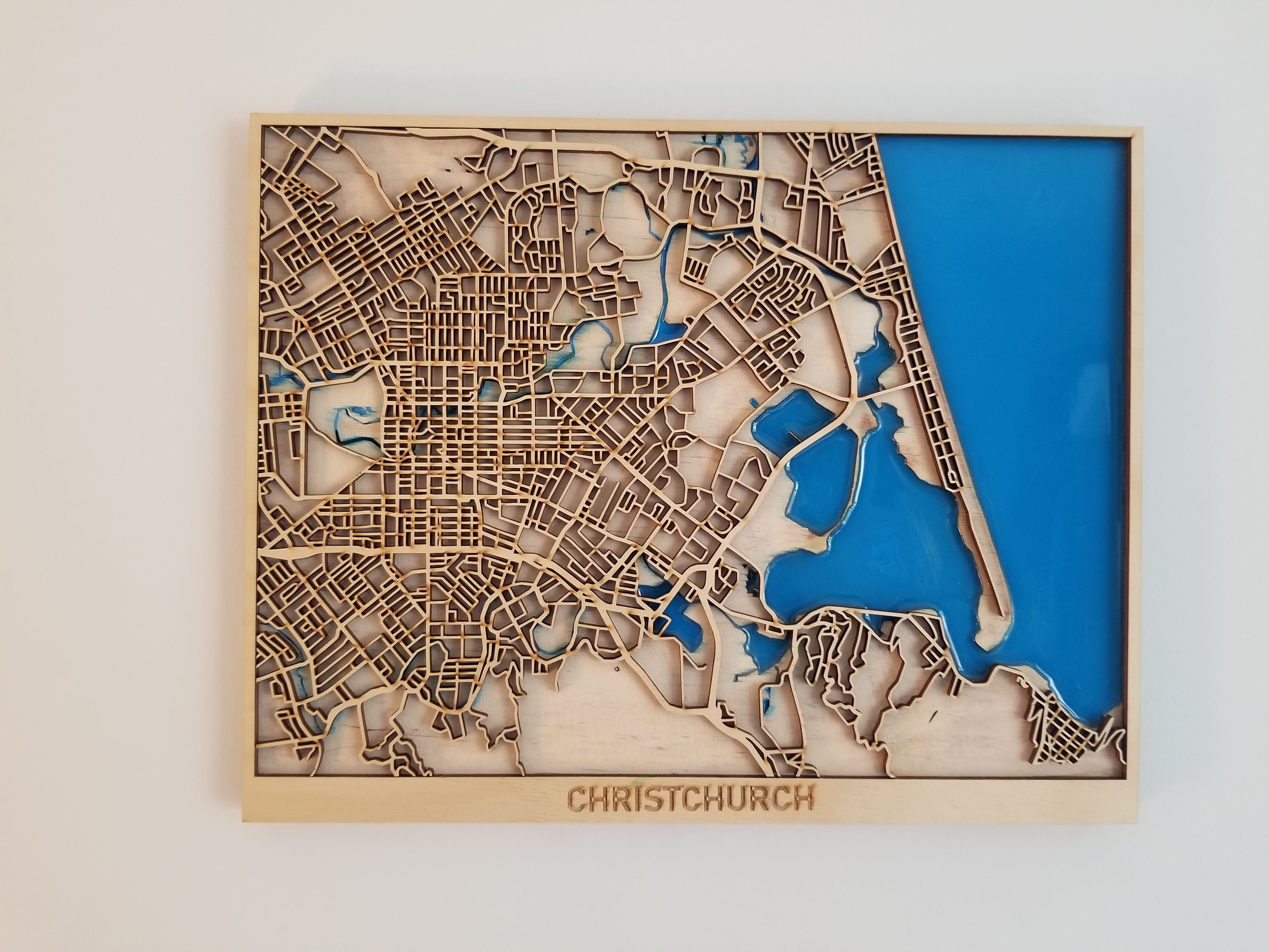 Laser-cut wooden map of Christchurch with epoxy-poured blue water